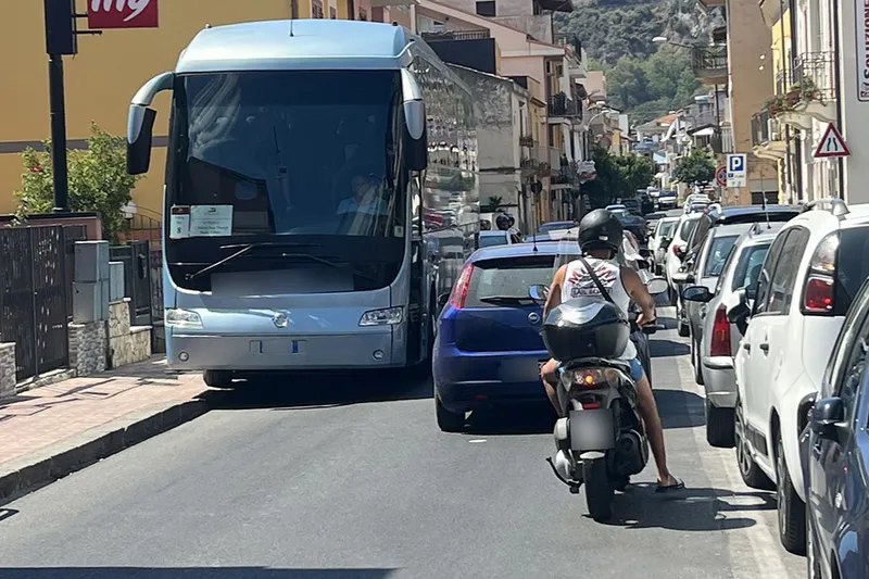 Narrow two-way street with buses and cars and heavy traffic in Southern Italy