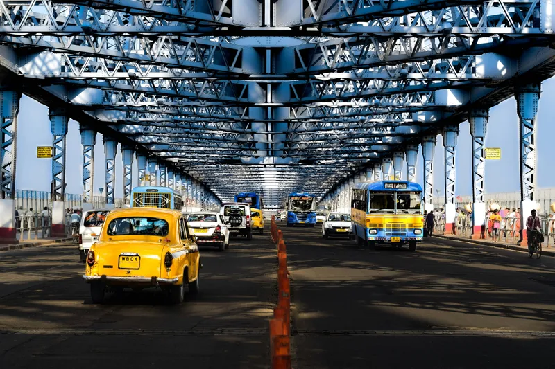 Yellow taxi cabs on the Howrah Bridge in Kolkata, West Bengal, India. Photo by Sohan Rayguru on Unsplash.