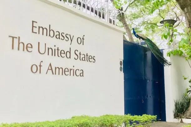 The wall of the U.S. Embassy in New Delhi in India with a peacock on the gate