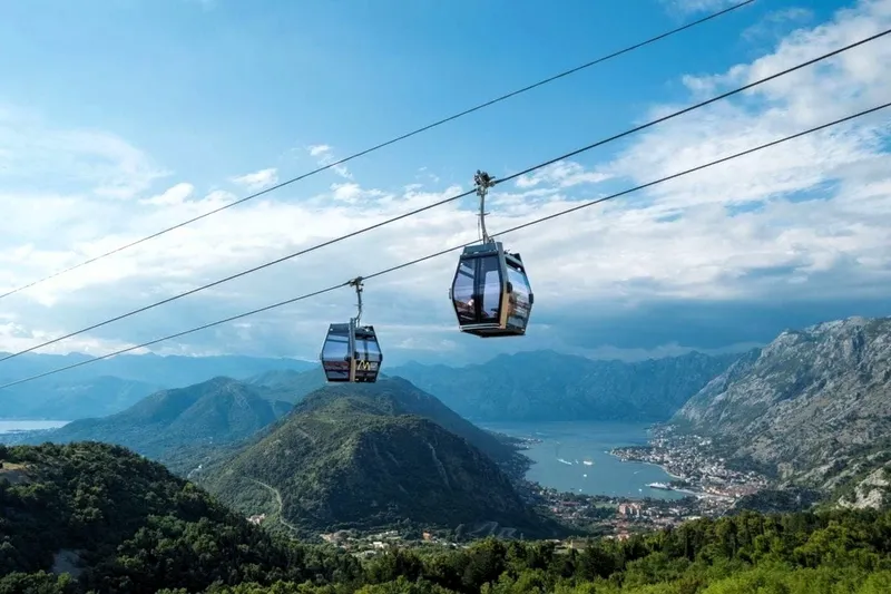 the Kotor cable car gondolas with a beautiful view of the Kotor Bay and Montenegro coastline in the background